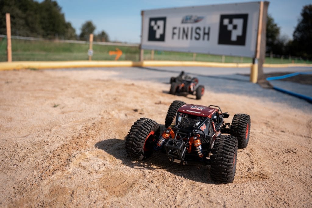 Two RC cars approaching the finish line at the Arcade One track